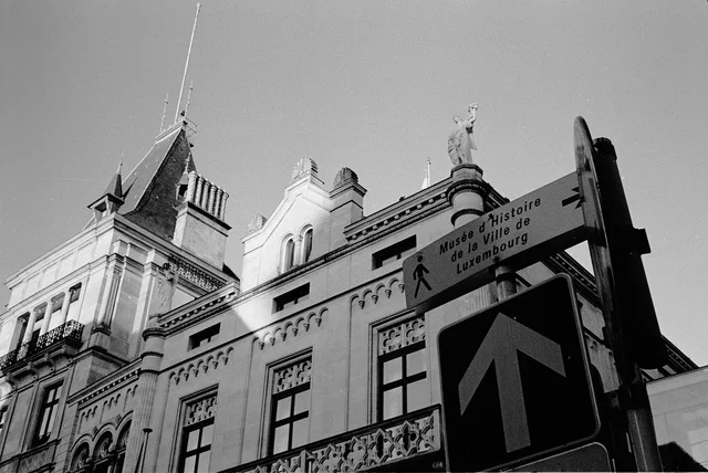A building facade and street signs viewed from below
