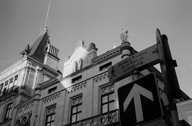 Ornate building facades rising behind a street sign with an upward arrow