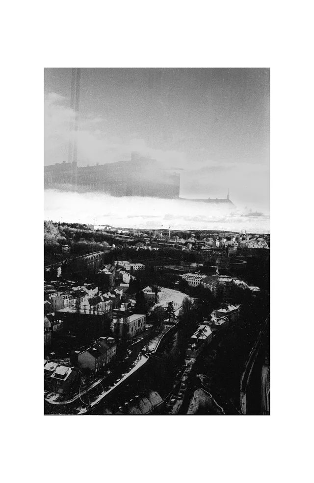 An elevated view across dense city buildings beneath a pale sky