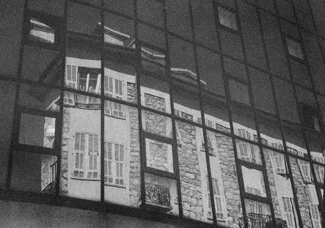 A building facade reflected in a grid of dark windows