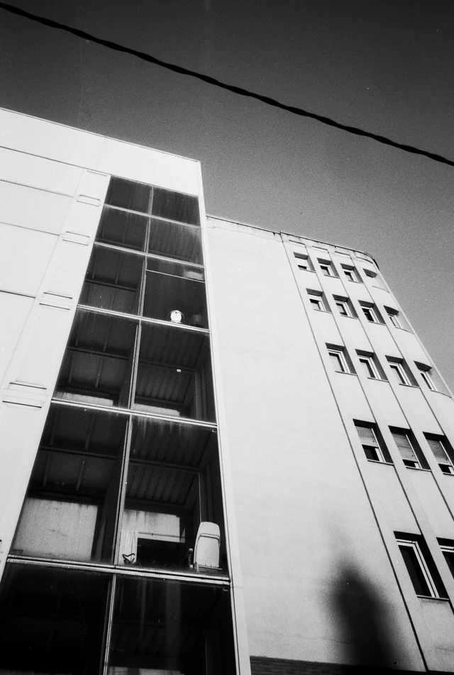 A geometric building facade with a tall strip of dark windows