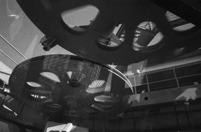Large spoked metal wheels beneath an industrial roof