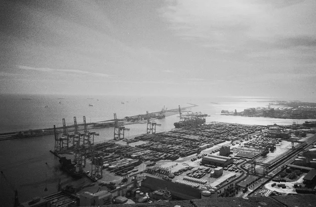 An elevated view of harbour cranes, container yards and open water