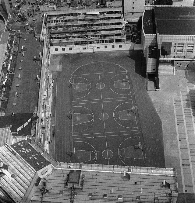 An overhead view of outdoor basketball courts surrounded by buildings