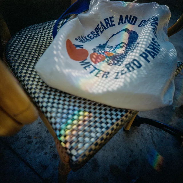 A printed tote bag resting on a woven chair