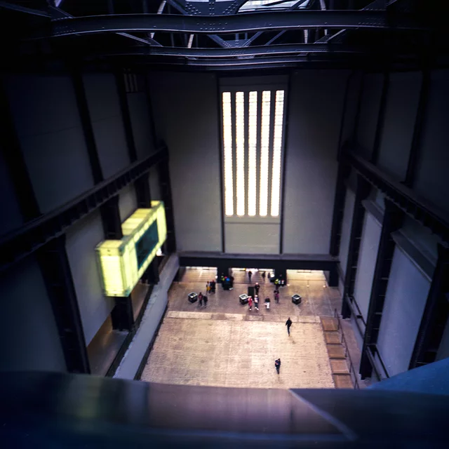 A high view into a tall hall, with small figures on the floor below