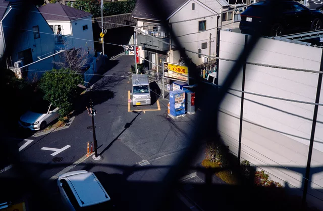 A small street intersection seen through dark foreground railings